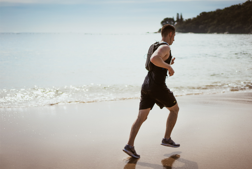 Deportista corriendo por la playa